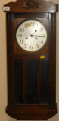 Lot 2095 - An oak cased wall clock, the circular silvered...