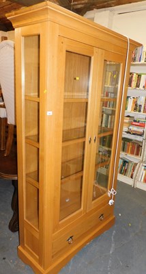 Lot 1005 - A contemporary oak bookcase, the top with a...
