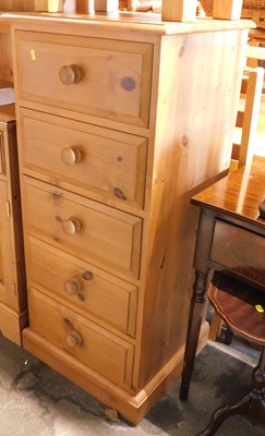 Lot 1070 - A pine narrow chest of five drawers, on a...