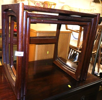 Lot 1147 - A teak nest of three tables, on U shaped...