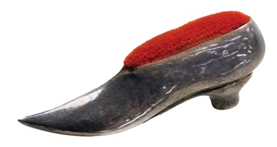 Lot 591 - A silver pin cushion, modelled as a lady's...