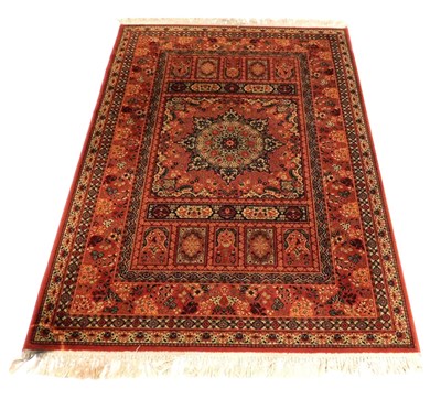 Lot 874 - A Kashan red ground rug, the central...