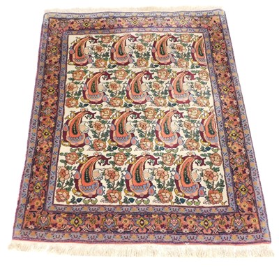 Lot 876 - A Persian cream ground wool rug, the central...