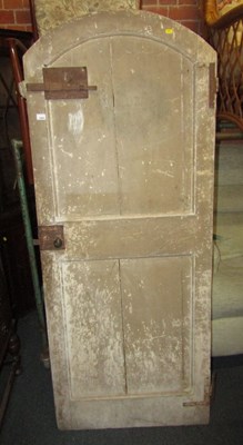 Lot 1045 - An arched antique pine door with iron fittings,...