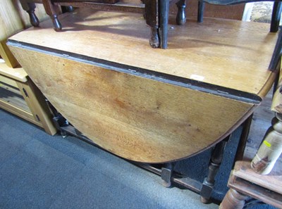 Lot 1065 - A large oak gateleg dining table, raised on...
