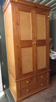 Lot 1003 - A pine double door wardrobe, with caned...