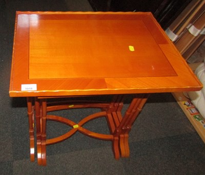 Lot 1018 - A nest of three yew tables, with inlay, the...