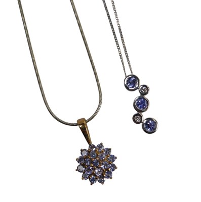 Lot 595 - A three stone tanzanite and two stone diamond...
