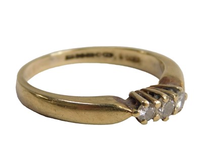 Lot 604 - A 9ct gold and diamond three stone ring, claw...