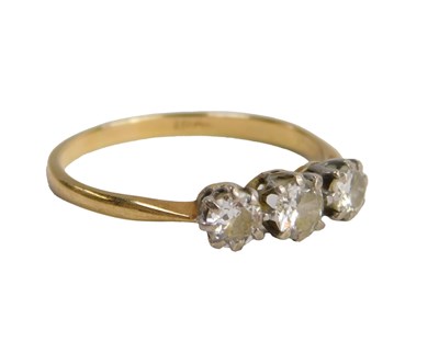 Lot 613 - A diamond three stone ring, claw set, yellow...