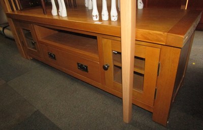Lot 1081 - A lightwood television stand, with two glazed...