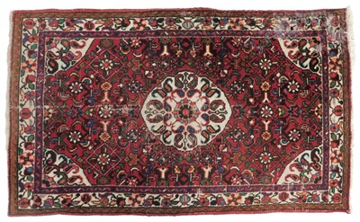 Lot 826 - A Persian red ground rug, with central...