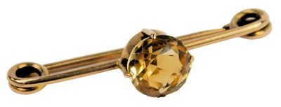 Lot 324 - A citrine single stone bar brooch, on a safety...