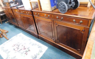 Lot 1611 - A set of three mahogany side cabinets, in...