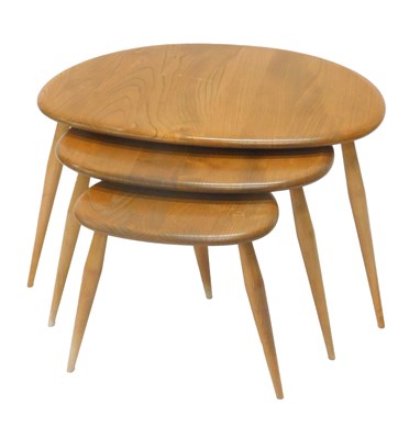Lot 16 - A nest of three Ercol light elm pebble tables,...