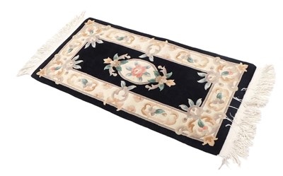 Lot 1032 - A small Chinese rug, with a design of flowers,...