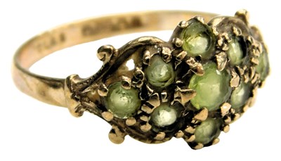 Lot 522 - A 9ct gold and peridot ring, in a floral and...