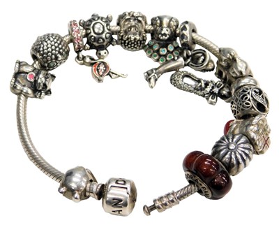 Lot 579 - A Pandora bracelet, with fourteen charms, on a...
