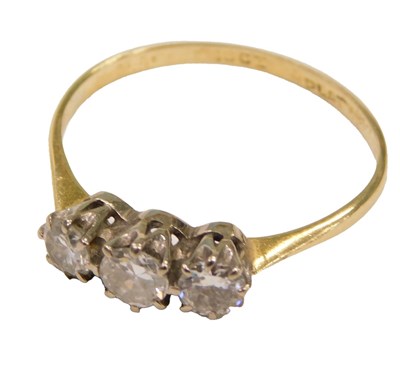 Lot 562 - A diamond three stone ring, claw set in white...