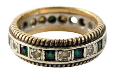 Lot 627 - A 9ct gold emerald and diamond eternity ring,...