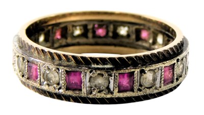 Lot 628 - A ruby and CZ eternity ring, in white and...
