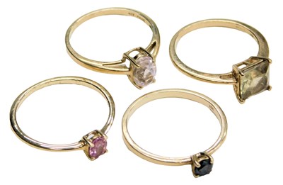Lot 724 - Four 9ct gold and gem set solitaire...