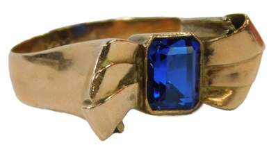 Lot 23 - A blue stone bow ring, the emerald cut blue...