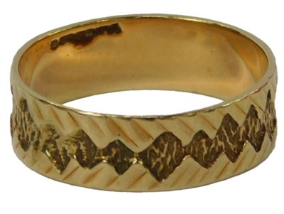 Lot 35 - A 9ct gold wedding band, with incised and...