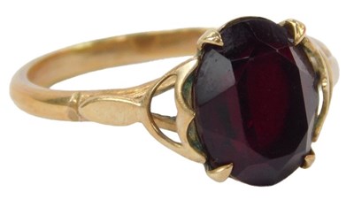 Lot 38 - A garnet dress ring, claw set, yellow metal...