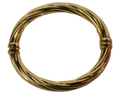 Lot 89 - A bangle of twisted design, with a figure...