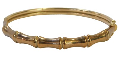 Lot 91 - A 9ct gold bangle, with half bamboo decoration,...