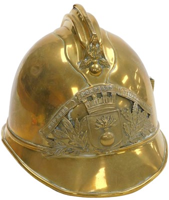Lot 537 - A French brass fire helmet, bearing a coat of...
