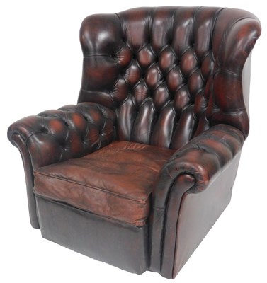 Lot 805 - A brown leather wing armchair, with button...