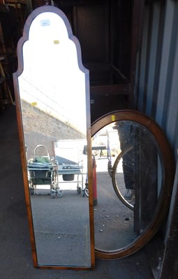 Lot 1077 - A walnut framed wall mirror, with a shaped top,...