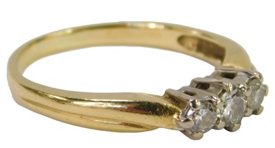 Lot 475 - A 18ct gold three stone diamond ring, on part...