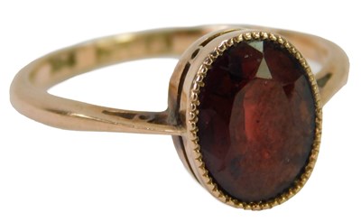 Lot 616 - A garnet dress ring, the oval garnet bezel set...