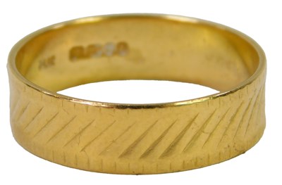 Lot 625 - A 22ct gold wedding band, with line decoration,...