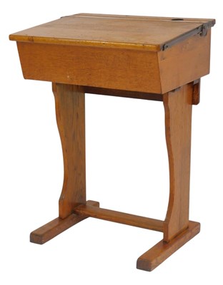 Lot 817 - A 20thC oak child's desk, the hinged top...
