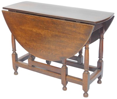 Lot 595 - A large oak oval drop leaf dining table, in...