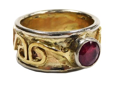 Lot 318 - A solitaire ruby band, in yellow and white...
