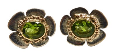 Lot 334 - A pair of peridot flowerhead cufflinks, the...