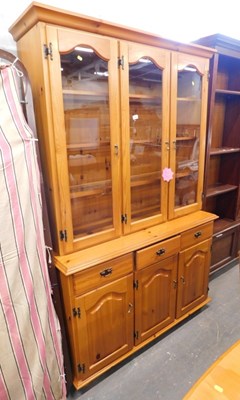 Lot 1567 - A stained pine bookcase, with three glazed...