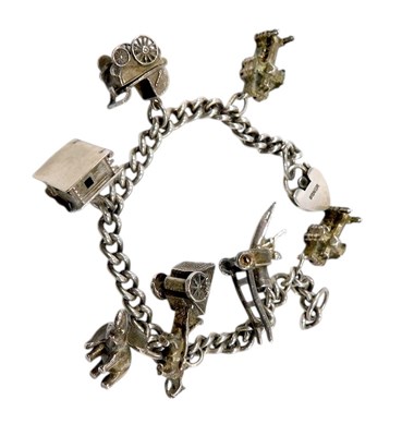 Lot 640 - A silver curb link charm bracelet, on a heart...