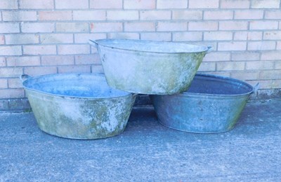Lot 1219 - Three galvanised metal twin handled wash tubs,...