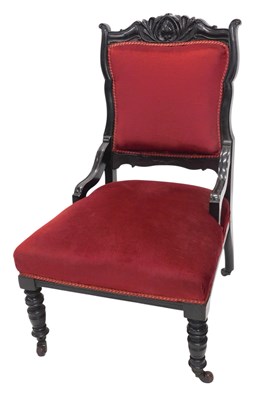 Lot 1157 - A late Victorian ebonised nursing chair, with...