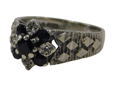 Lot 671a - A 9ct white gold, sapphire, and diamond flower...