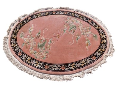 Lot 1166 - A large Chinese pink ground rug, decorated...