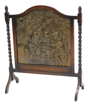 Lot 1191 - A 1920s oak firescreen, with embossed brass...
