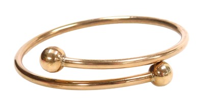 Lot 584 - A 9ct hollow rose gold bangle, with ball...