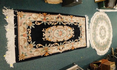 Lot 1682 - A small Chinese cut wool rug, on a black...